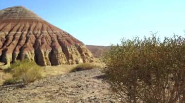 Bozkırda Aktau 'nun renkli dağları. Çölün ortasındaki kireçtaşı dağları. Beyazdan kırmızıya renkli tepeler. Dünya kayaları katmanlarla ayrılır. Kocaman bir kanyon. Altyn Emel.