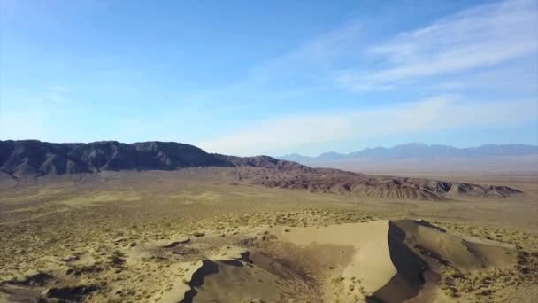 カザフスタンの巨大な砂丘 歌の砂丘のドローンからのトップビュー 人々のグループは 山の上に休んでいる 黄色の砂の多くは 人々の痕跡が表示されます 雲のある青空 — ストック動画