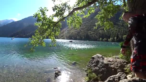 Tizio Con Uno Zaino Siede Una Roccia Vicino Lago Guardando — Video Stock