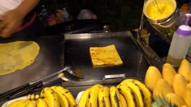 Asya 'da yiyecek dolu bir cadde. Çok çeşitli. Asyalılar gözleme, kebap, yemek, mısır, balık, meyve suyu, milkshake hazırlar. Farklı meyveler satıyorlar. Yemek pişirirken gülümser ve dans ederler. Tayland sokak yemeği..