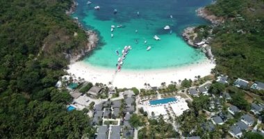 Turkuaz su rengi ve beyaz kum. İnsansız hava aracından, havadan görüntü. Suyun mavi ile koyu mavinin gradyanı. Phuket 'teki Racha adasının yeşil palmiye ağaçları ve tarlaları. Cennetlik kumsal. Tayland