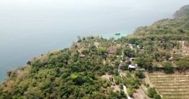 Turkuaz su rengi ve beyaz kum. İnsansız hava aracından, havadan görüntü. Suyun mavi ile koyu mavinin gradyanı. Phuket 'teki Racha adasının yeşil palmiye ağaçları ve tarlaları. Cennetlik kumsal. Tayland