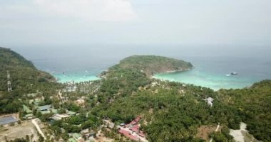 Turkuaz su rengi ve beyaz kum. İnsansız hava aracından, havadan görüntü. Suyun mavi ile koyu mavinin gradyanı. Phuket 'teki Racha adasının yeşil palmiye ağaçları ve tarlaları. Cennetlik kumsal. Tayland