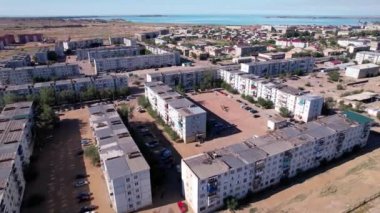 The small town of Balkhash is a view from a drone. There are new and old houses, playgrounds are being built. Cars are driving on the roads. A city in the middle of the steppe, but next to a lake