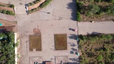 Sokak boyunca çatısı olan bisikletli insanlar. Çiçekler çiçek tarlalarında yetişir. Çok az yeşil ağaç var. Döşeme taşlarını değiştiriyorlar. İHA 'nın üst görüntüsü. Balkhash seti üzerinde güneşli bir gün