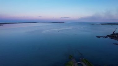 The embankment of the city of Balkhash. A ship is sailing on the lake. Dark green water, calm. Visible streaks of waves from the motor. Bertys Bay. People walk along the beach and alleys. Kazakhstan