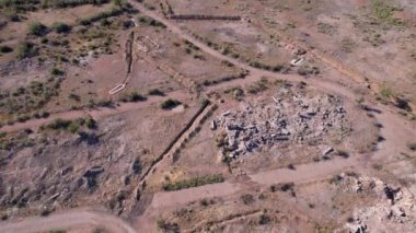 A view from the height of a drone on an old broken abandoned camp on the shore of Lake Balkhash. The paths are overgrown with bushes, there are bricks and metal. People relax on the beach