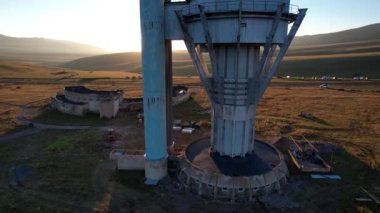 Bright dawn over the Assy-Turgen Observatory in the mountains. Aerial view from the drone of the camp of tents, cars and waking tourists. There is an old abandoned building. Kazakhstan, Almaty