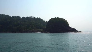Tayland 'da gemiyle seyahat et. Açık okyanus manzarası, yeşil adalar ve sisli gri gökyüzü. Dalgalı yeşil su. Adalar arasında yelken açmak. Farklı taraflardan gemi: kıç, yay, halat, çapa.