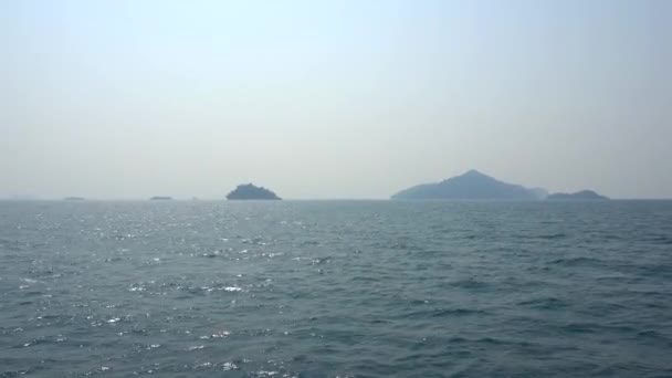 船でタイの海の旅 スモッグのオープン海 緑の島と灰色の空のビュー 波と緑の水 島の間を航海する 異なる側面からの船 ロープ アンカー — ストック動画