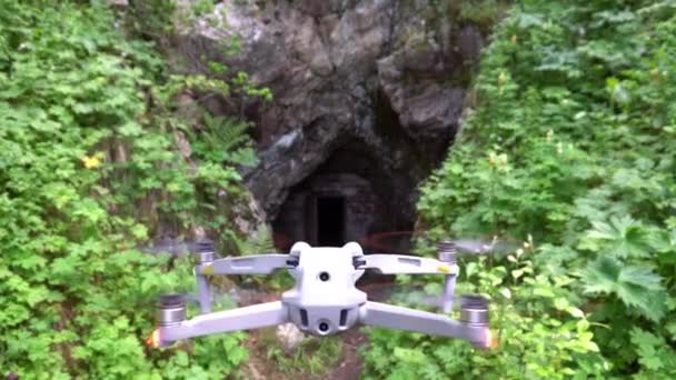 Dji Air2S Quadcopter Hovers Front Cave Entrance Green Bushes Grass — Stock Video