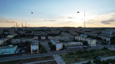 Gün batımında bir kuş sürüsü şehrin üzerinde uçar. Küçük Balkhash kasabası. Uzun bir televizyon kulesi var, fabrika ağır şekilde sigara içiyor. Arabalar yollarda gider. Bir kırlangıç sürüsü cüceleri ve dronları yakalar.