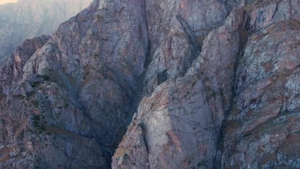 俯瞰有陡峭悬崖的大石头 绿色的灌木丛生长在小山的山崖上 黄色的草枯干了 攀爬有许多裂缝 山中的薄雾 哈萨克斯坦 — 图库视频影像