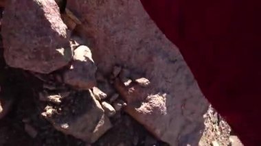 Dağlardaki kayaların ve kayaların üzerinden destansı bir iniş. Birinci şahıs görüşü. Takım elbiseli ve eldivenli bir adam kaygan kumda yürüyor. Güçlü bir eğimle dik bir yokuş. Taşlar düşüyor. Tırmanma