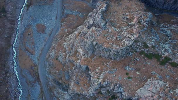 峡谷中陡峭的悬崖 还有一条河 峡谷边有一条土路 一些地方长出了绿色的灌木丛和黄色的青草 秋天来了 哈萨克斯坦 — 图库视频影像