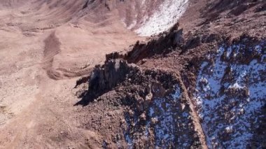 Karlı kayalık dağ tepeleri açık bir sis bulutu içinde. Mavi gökyüzünün insansız hava aracı, açık sis ve dik tepeli uçurumlar. Uzaktan bir moraine gölü görülebilir. Eski buzullar. Kazakistan