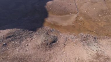 Sonbahar dağları. Nehir vadide kurudu. İHA 'nın sarı çimlerdeki ve bazen de yeşil çalılardaki görüntüsü. Nehir yatağı neredeyse kurudu. Gri duman uzaktan görülebilir. Kazakistan