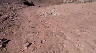 Dik geçitten Moraine Gölü 'nün manzarası. Suyun rengi zümrüt, koyu yeşil. Dik kayalar ve kayaların arasındaki vadide bir dağ gölü. Sarı otlar bazı yerlerde görülebilir. Bulutlar