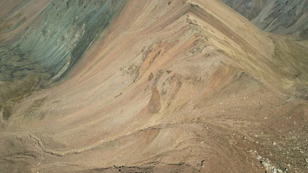 山路陡峭的山路和岩石 岩石地形 下落的岩石和融化的冰川的痕迹是可见的 悬崖休息 有些地方有雪 从无人机上俯瞰 哈萨克斯坦 — 图库照片