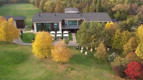 高尔夫公园里漂亮的房子 秋天的黄红树 在绿草 有帐篷的咖啡馆里 从无人机俯瞰着 度假和度假的地方 日落时分 — 图库视频影像