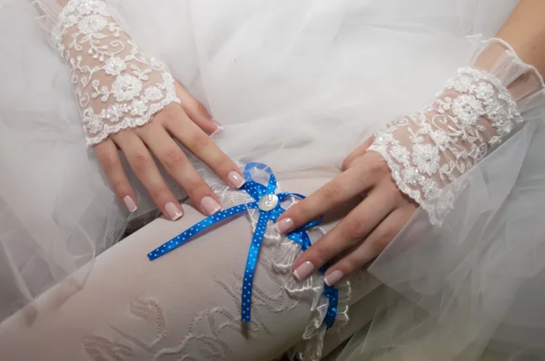 Bride dresses garter on the leg. Picture of beautiful female bar — Stock Photo, Image