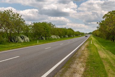 Gagauzja, Moldova Cumhuriyeti - 02 Mayıs 2016: Çayırlar ve tarlalar arasında bir köy yolu. Bahar mevsimi kırsal alan.