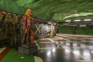 Stockholm, İsveç - 29 Mayıs 2016: Kayadan oyulmuş Kungstradgarden metro istasyonunda heykel. Yeşil duvarlar.