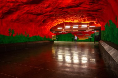 Stockholm, İsveç - 25 Haziran 2016: Solna Centrum İstasyonu, taştan oyulmuş metro istasyonu. Boyalı kırmızı duvarlar.