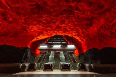 Stockholm, İsveç - 25 Haziran 2016: Solna Centrum İstasyonu 'nda yürüyen merdiven, kayadan oyulmuş metro istasyonu. Kırmızı duvarlar.