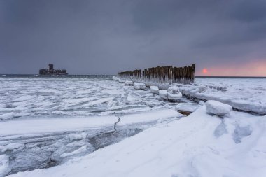 İkinci Dünya Savaşı torpido platformu Baltık denizde ahşap dalgakıranlar hattına donmuş. Donmuş sabah Babie Doly, Polonya. Uzun pozlama fotoğraf.