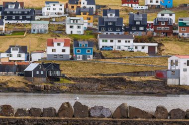 Sandavagur, Faroe Adaları - 29 Nisan 2018: Vagar Adası 'ndaki Sandavagur manzarası. Bir tepenin yamacında küçük bir köy..
