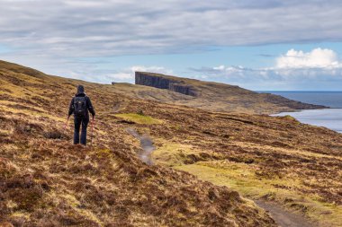 Traelanipa, Faroe Adaları - 29 Nisan 2018: Yürüme yolu üzerindeki turistler, turba tarlasına giden eski yol, bir Traelanipan Patikası. Vagar adasında bulutlu bir gün.