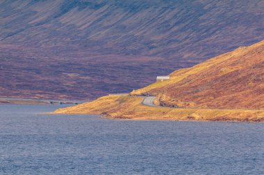 Okyanusun üzerindeki Leitisvatn Gölü manzarası. Yürüme alanı, turba tarlası, Traelanipan Patikası. Vagar adasında bulutlu bir gün. Faroe Adaları.
