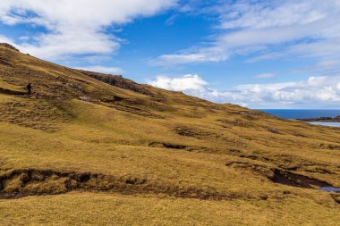 Okyanusun üzerindeki Leitisvatn Gölü manzarası. Yürüme alanı, turba tarlası, Traelanipan Patikası. Vagar adasında bulutlu bir gün. Faroe Adaları.