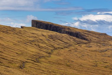 Okyanusun üzerindeki Leitisvatn Gölü manzarası. Yürüme alanı, turba tarlası, Traelanipan Patikası. Vagar adasında bulutlu bir gün. Faroe Adaları.