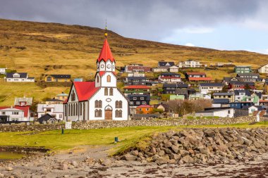 Sandavags Kirkja manzarası, Vagar Adası 'ndaki Sandavagur kilisesi. Bir tepenin yamacında küçük bir köy. Faroe Adaları.