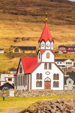Sandavags Kirkja manzarası, Vagar Adası 'ndaki Sandavagur kilisesi. Bir tepenin yamacında küçük bir köy. Faroe Adaları.