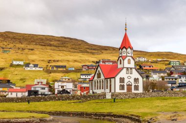 Sandavags Kirkja manzarası, Vagar Adası 'ndaki Sandavagur kilisesi. Bir tepenin yamacında küçük bir köy. Faroe Adaları.