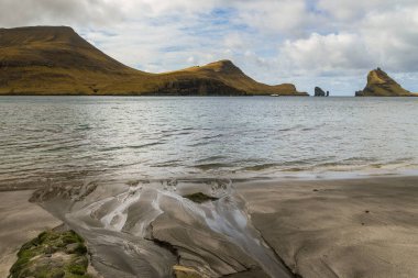 Vagar Adası 'ndaki Bour yakınlarındaki sahil manzarası. Devasa uçurumlar, uçurumlar ve okyanus manzarası. Vagar Adası 'nda bir otobüs. Faroe Adaları.