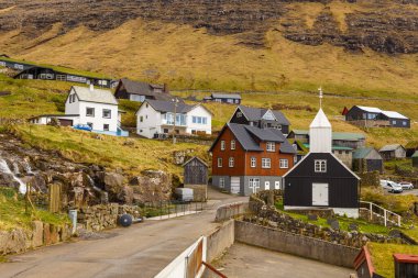 Bour, Faroe Adaları - 30 Nisan 2018: Vagar Adası 'ndaki Bour' daki ahşap kilise manzarası. Bir tepenin yamacında küçük bir köy. Faroe Adaları.