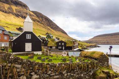 Bour, Faroe Adaları - 30 Nisan 2018: Vagar Adası 'ndaki Bour' daki ahşap kilise manzarası. Bir tepenin yamacında küçük bir köy. Faroe Adaları.