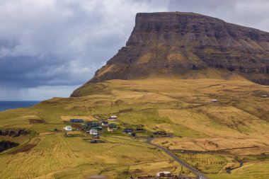 Vagar Adası 'ndaki Gasadalur manzarası. Bir tepenin yamacında küçük bir köy. Gasadalur, Faroe Adaları.