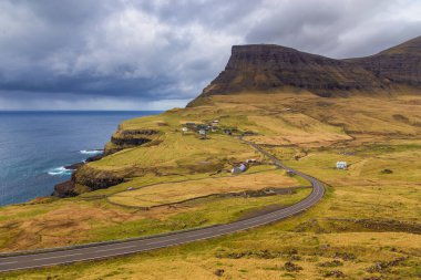Vagar Adası 'ndaki Gasadalur manzarası. Bir tepenin yamacında küçük bir köy. Gasadalur, Faroe Adaları.