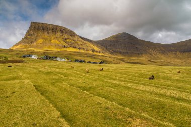 Vagar adasındaki dağ manzarası. Bulutlu bahar günü. Faroe Adaları.