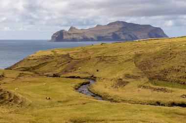 Vagar adasındaki dağ manzarası. Bulutlu bahar günü. Faroe Adaları.