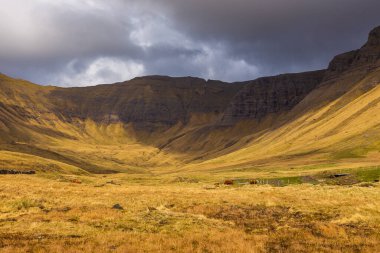 Vagar adasındaki dağ manzarası. Bulutlu bahar günü. Faroe Adaları.