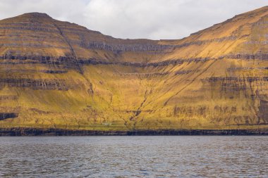 Kunoy ve Kalsoy adalarının dik kıyıları. Atlas Okyanusu, Faroe Adaları 'ndaki volkanik takımadalar.