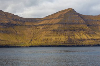 Kunoy ve Kalsoy adalarının dik kıyıları. Atlas Okyanusu, Faroe Adaları 'ndaki volkanik takımadalar.