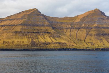 Kunoy ve Kalsoy adalarının dik kıyıları. Atlas Okyanusu, Faroe Adaları 'ndaki volkanik takımadalar.