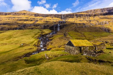 Güzel bir bahar manzarası. Faroe Adaları 'ndaki tipik çim çatılı evleri olan Saksun köyünün güneşli bahar manzarası. Streymoy Adası, Danimarka, Avrupa 'nın muhteşem manzarası.